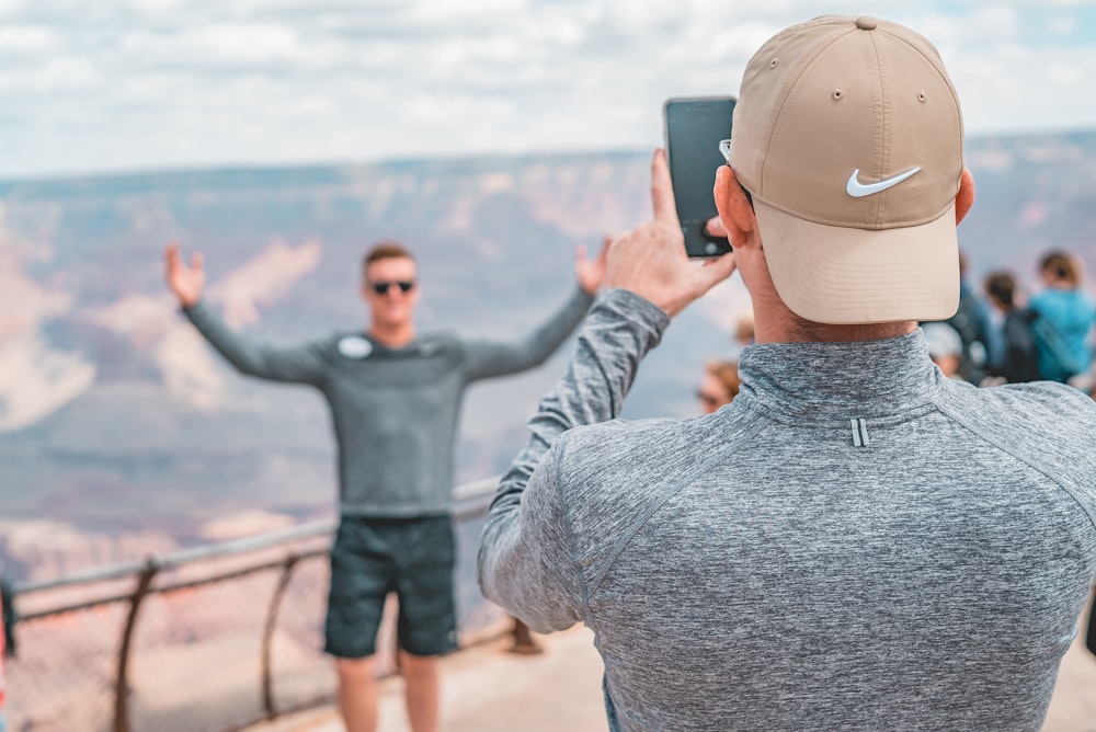 man in gray long sleeve shirt and gray cap using black binoculars