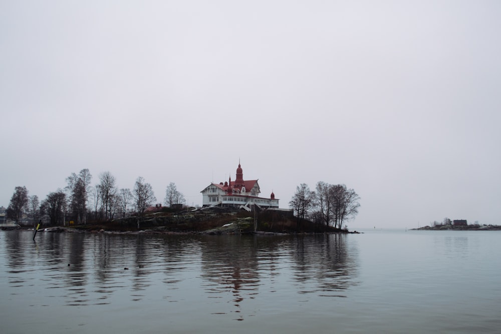 white and red house near body of water during daytime