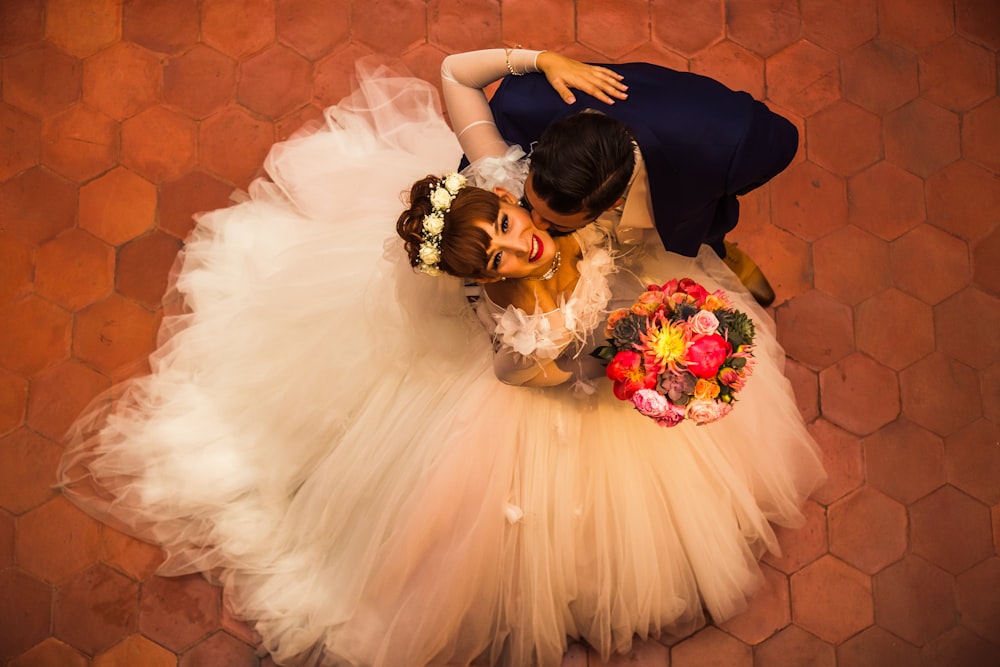 woman in white wedding dress holding bouquet of flowers