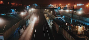 Evening scene of a busy urban station lit by warm lights with travelers hurrying along