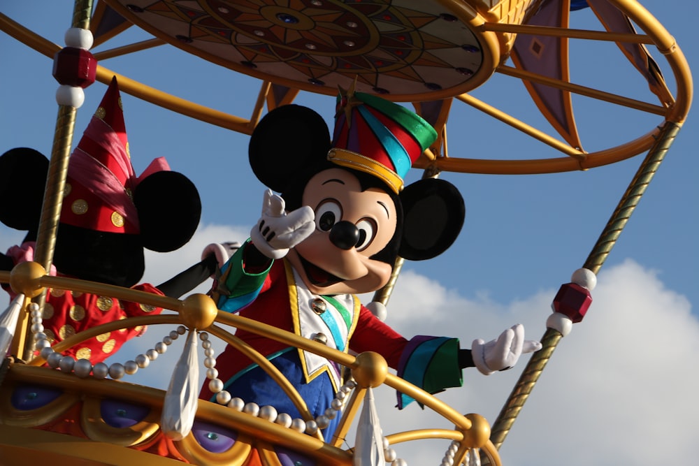 mickey mouse riding on yellow and red roller coaster during daytime