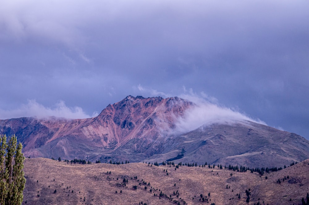 Montaña marrón y blanca bajo nubes blancas durante el día