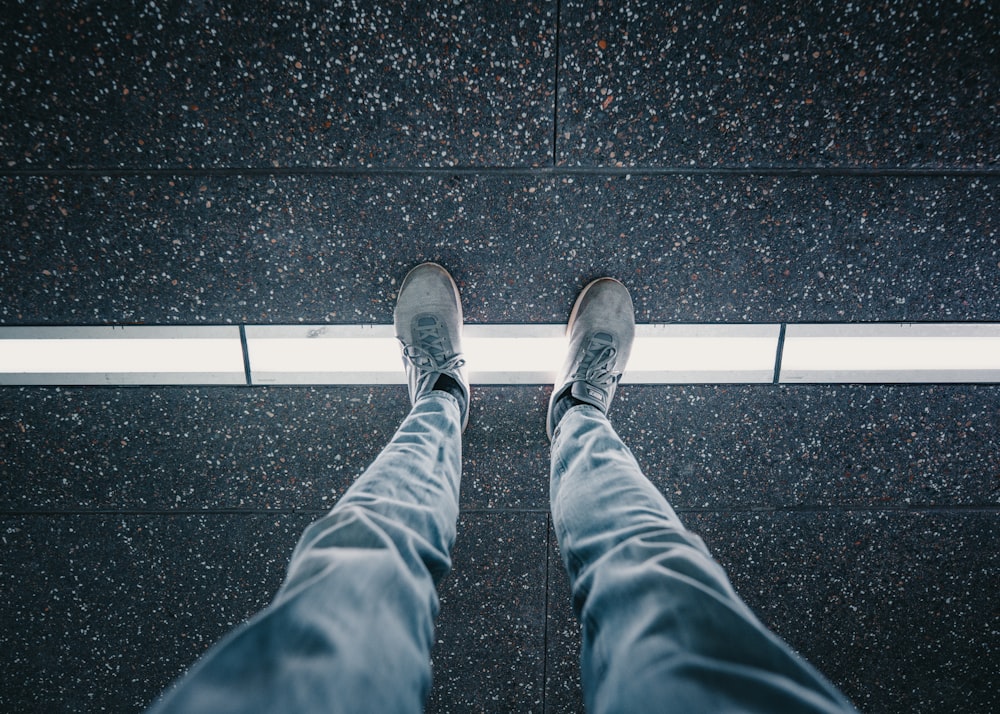 person in blue denim jeans and gray sneakers