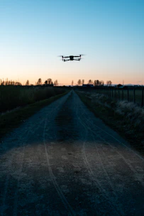 white drone flying over the green grass field during daytime
