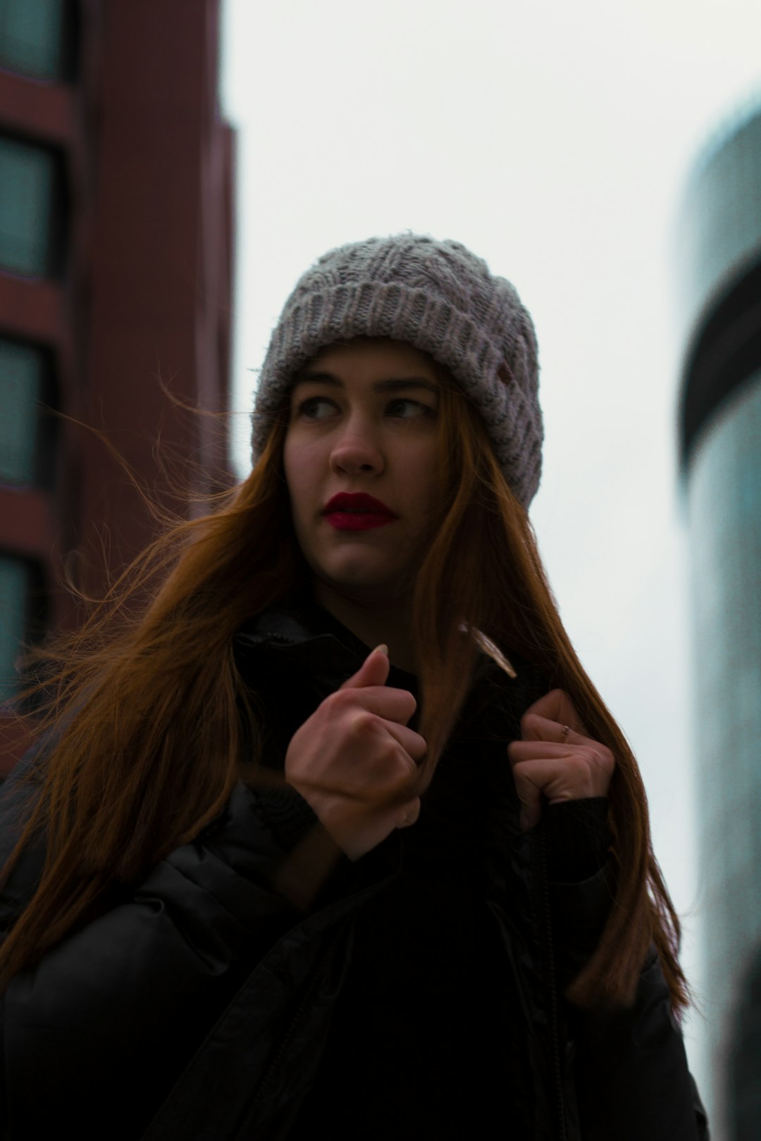 woman in black jacket wearing gray knit cap