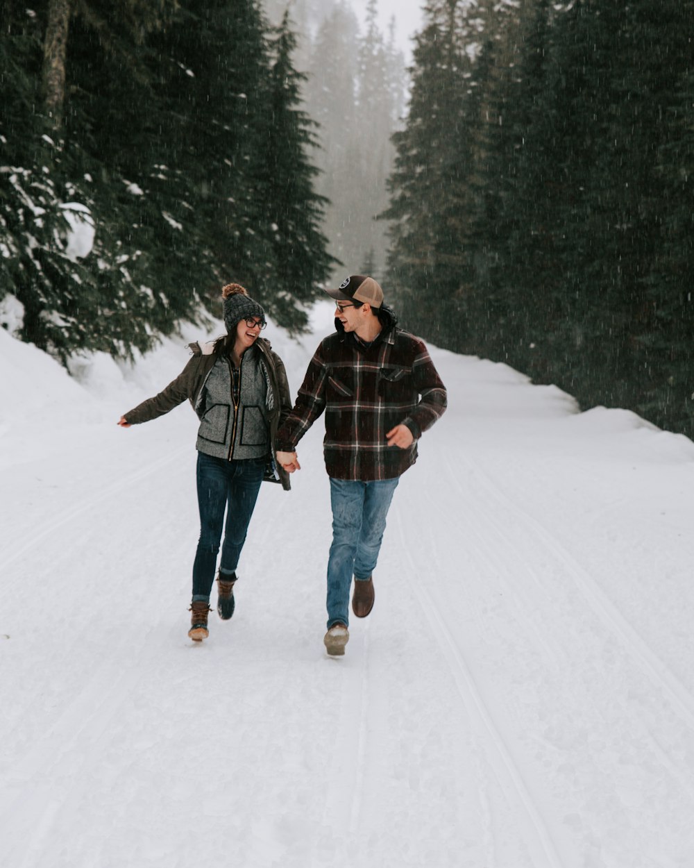 man and woman standing on snow covered ground during daytime