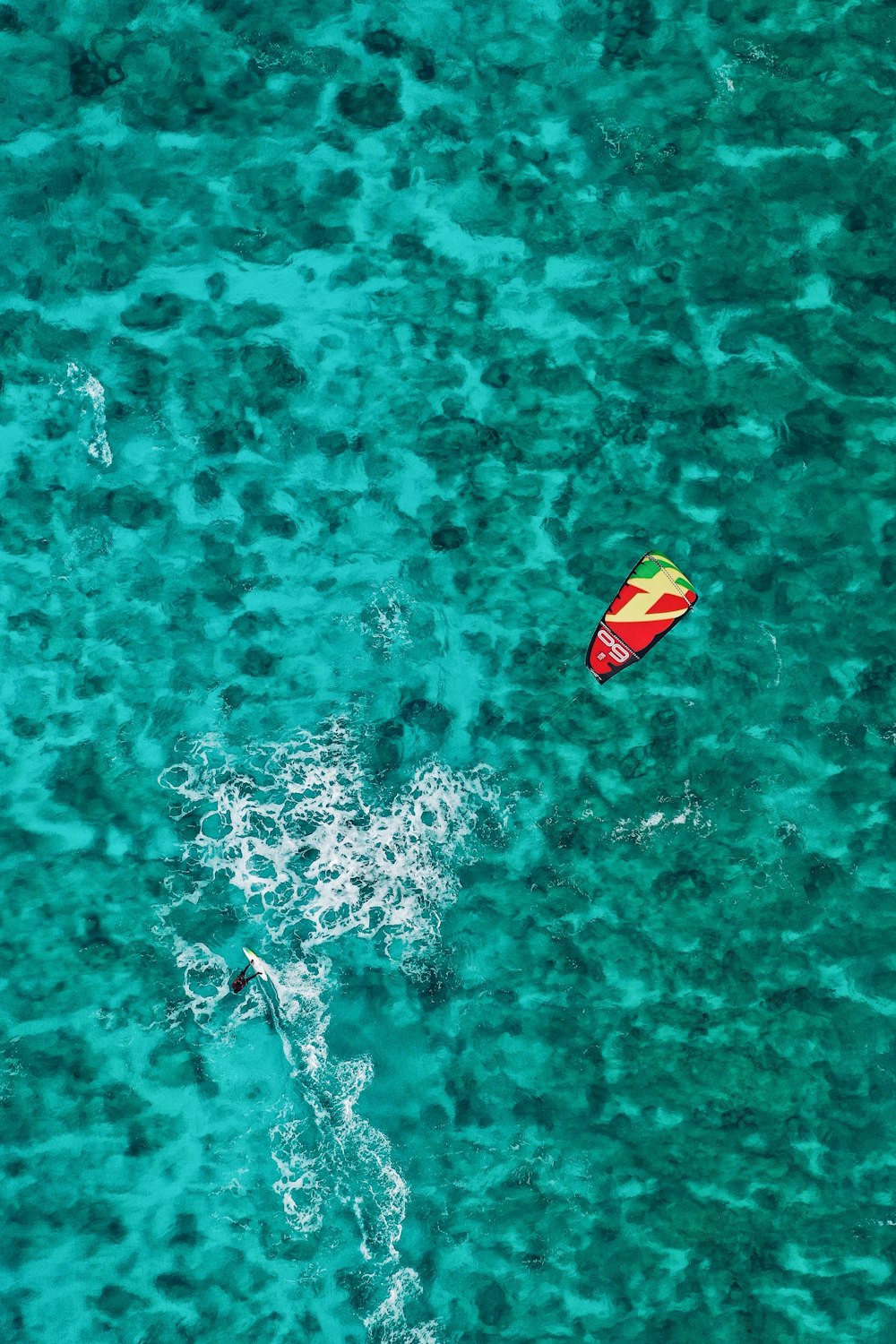Planche de surf jaune et rouge sur plan d’eau