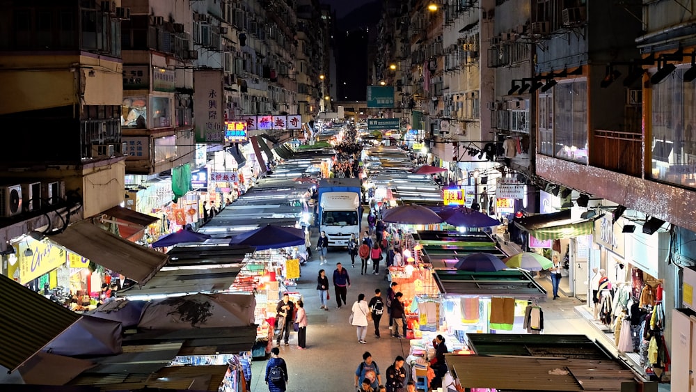 les gens qui marchent dans la rue avec des voitures garées sur le côté pendant la journée ;