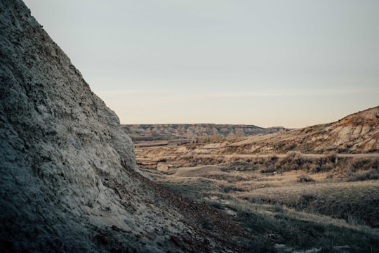 brown and gray rocky mountain under white sky during daytime in Dinosaur Provincial Park Canada