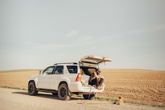 white suv on brown field during daytime in Alberta Canada