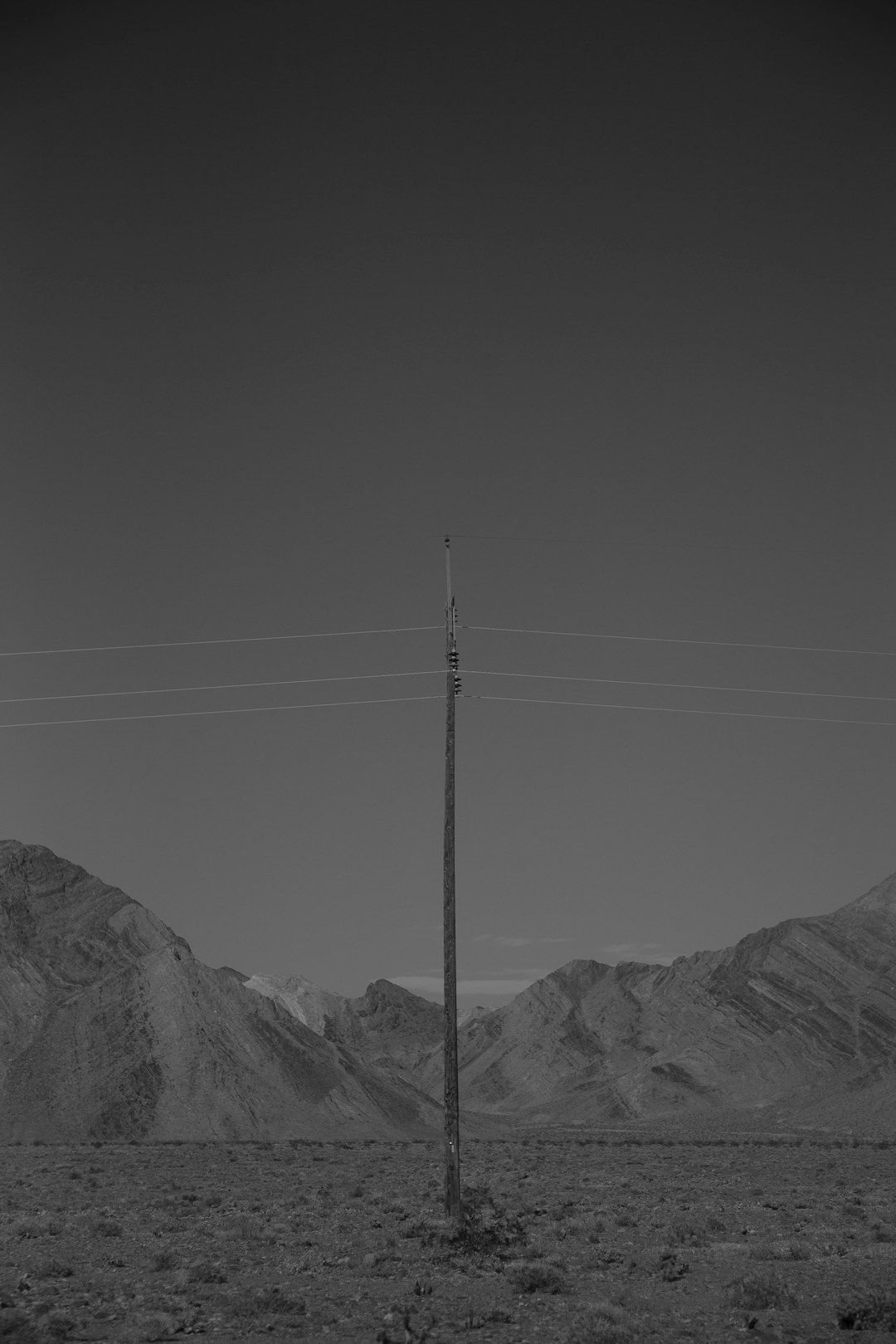 grayscale photo of mountains and electric post