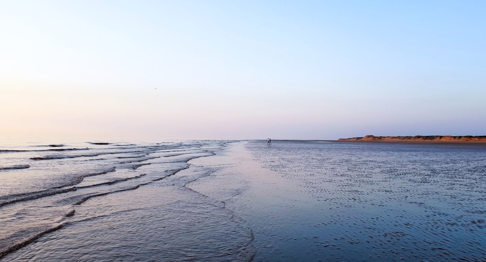 person walking on beach during daytime