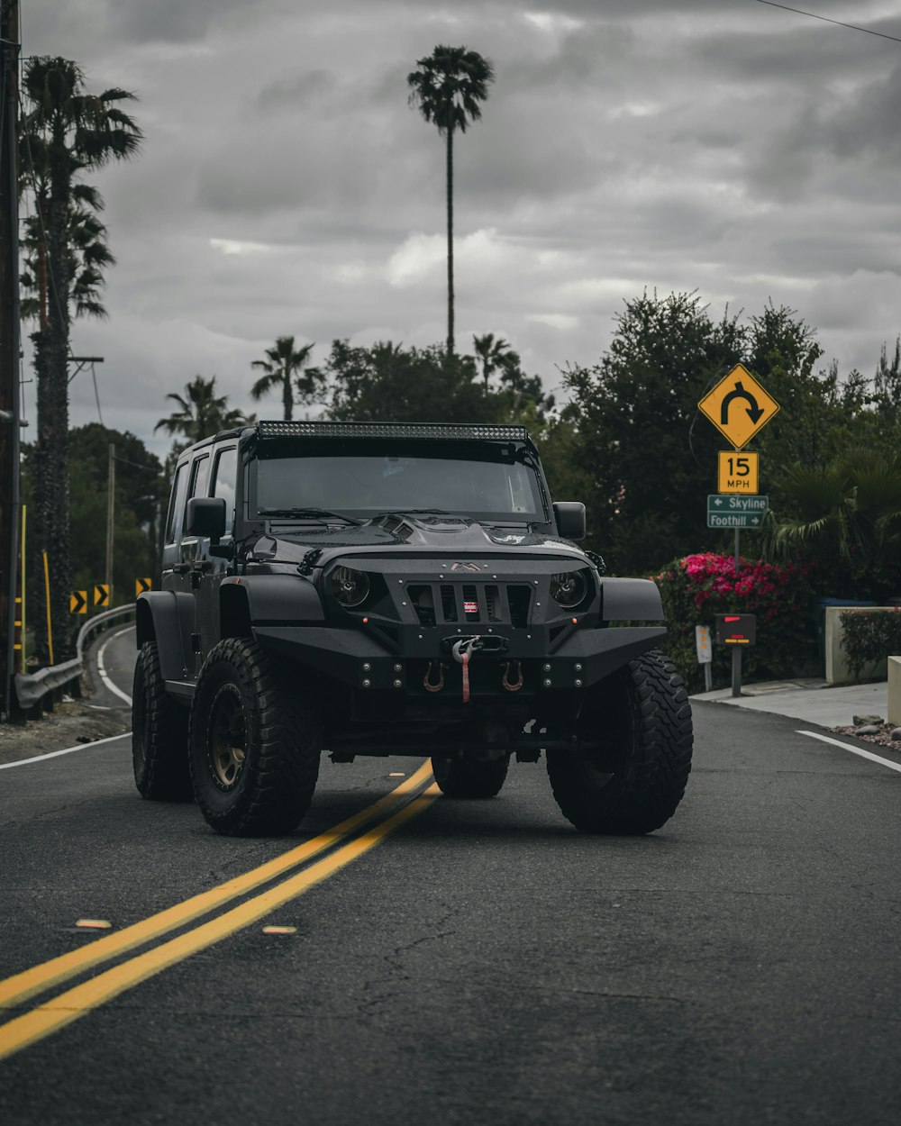 Schwarzer Jeep Wrangler tagsüber unterwegs