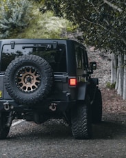 black jeep wrangler on dirt road during daytime