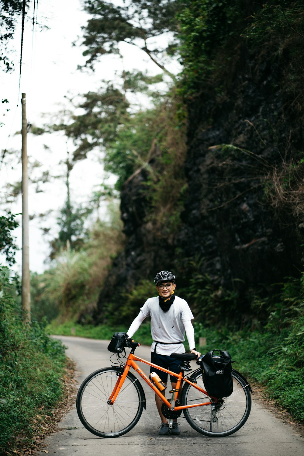 man in white shirt riding on red and black bicycle during daytime