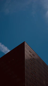 Modern residential building with sleek glass facade under clear sky.