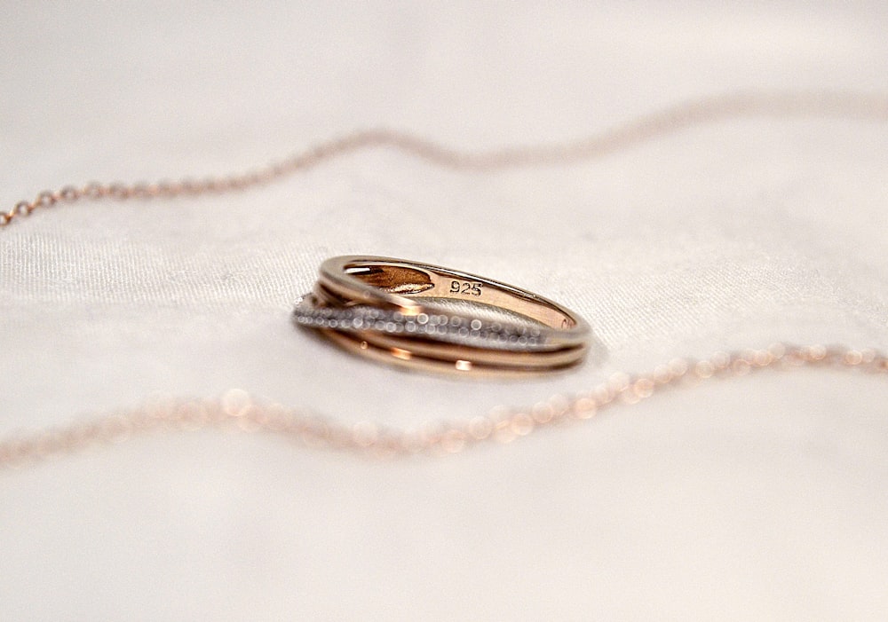 silver diamond ring on white textile