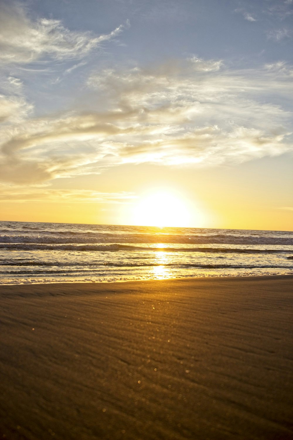 sea waves crashing on shore during sunset