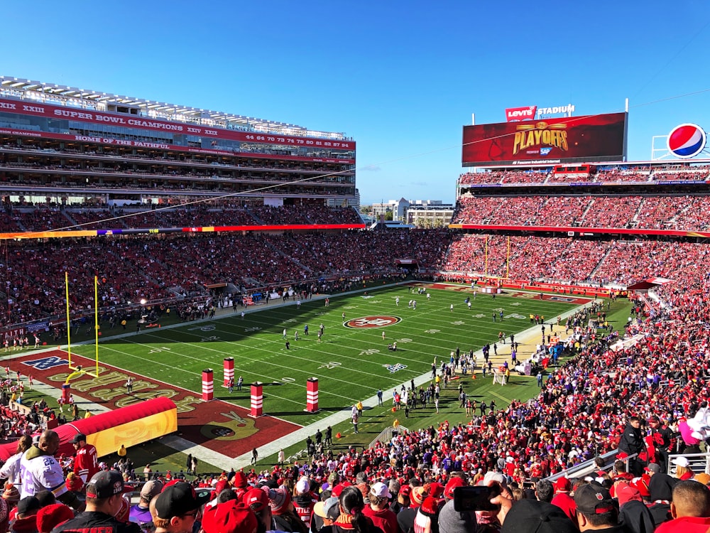 people watching football game during daytime