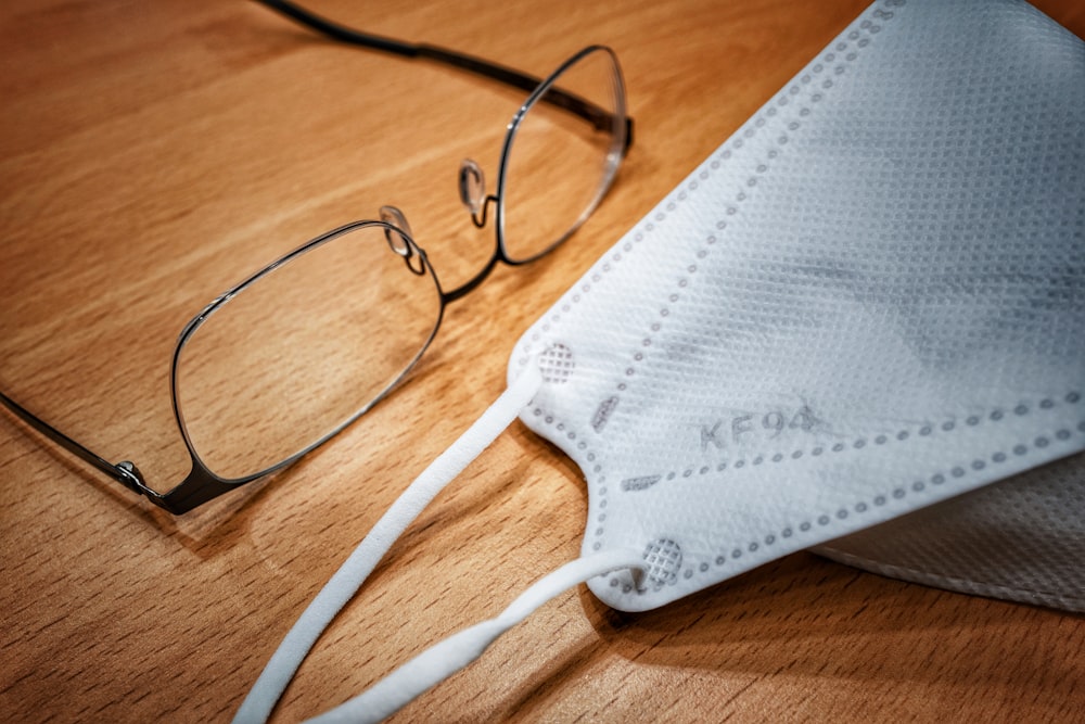 black framed eyeglasses on brown wooden table