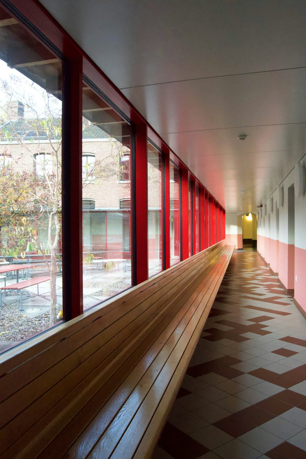 brown wooden bench near glass window