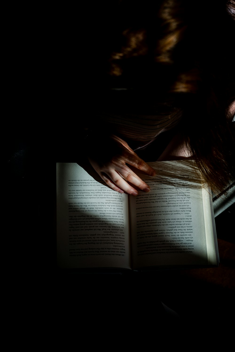 Mujer leyendo un libro sobre una mesa de madera marrón