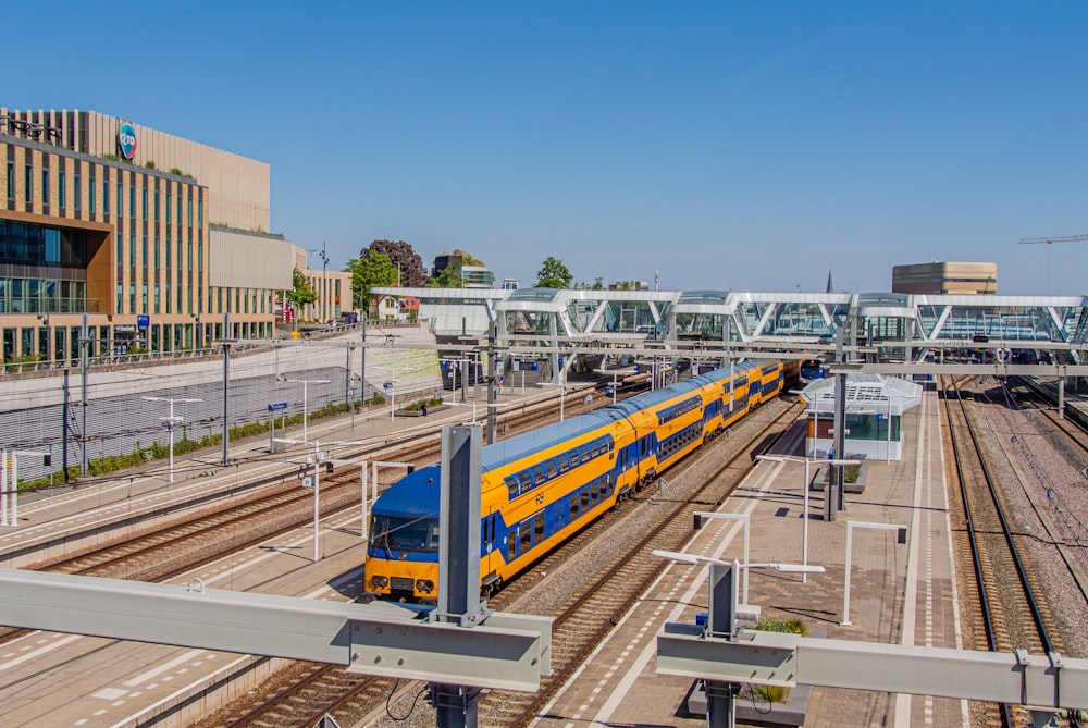 yellow and blue train on rail road during daytime