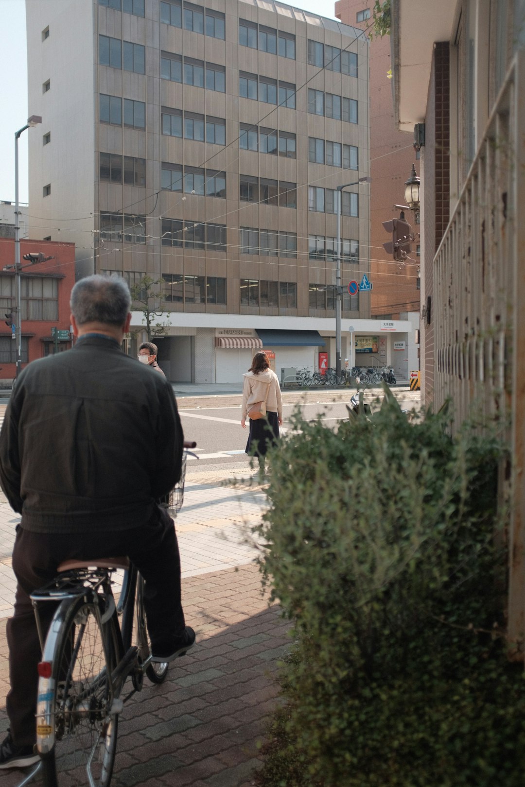 man in black jacket riding bicycle during daytime