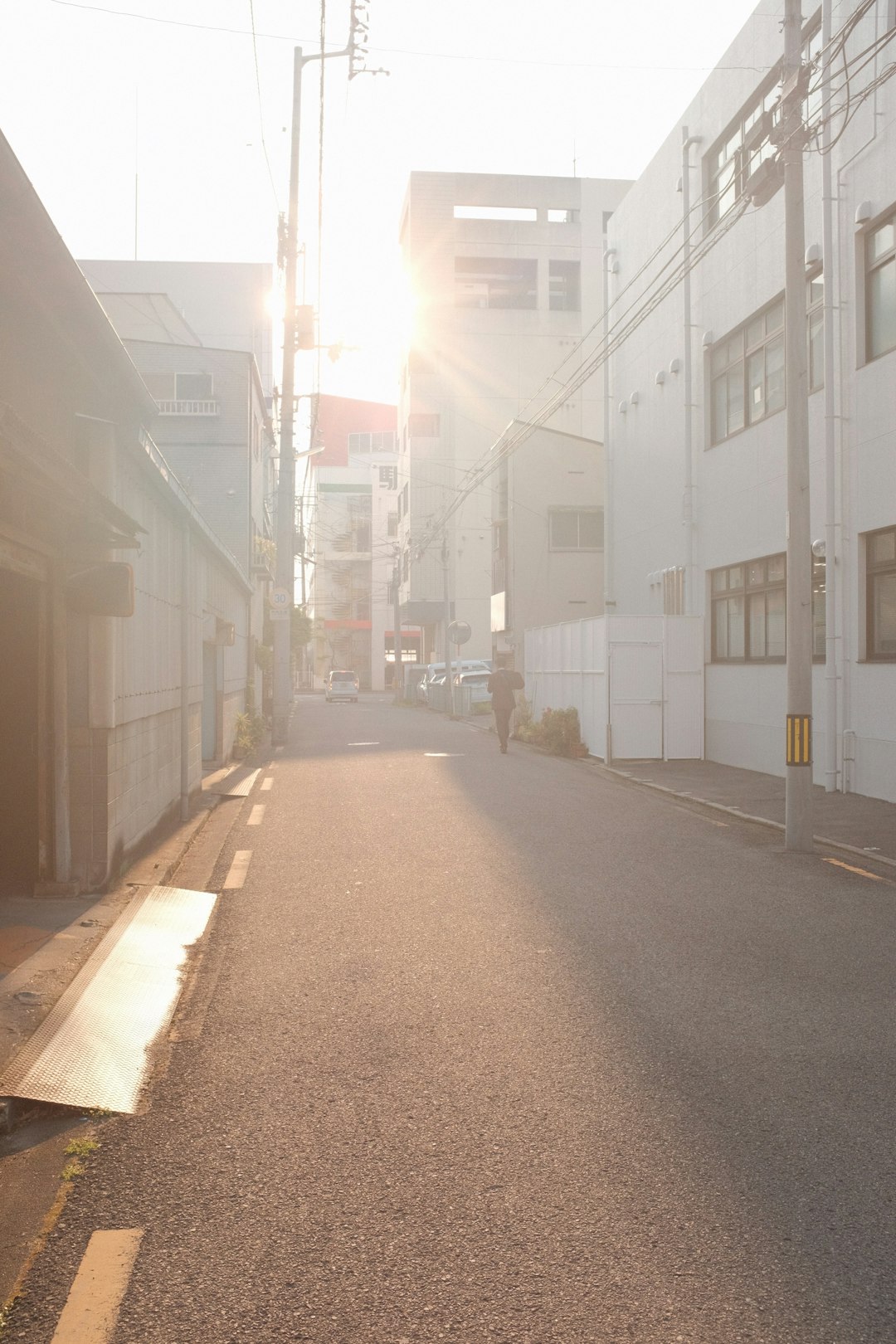 empty street between white concrete buildings during daytime