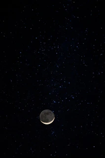 A mystical postcard showing a crescent moon surrounded by stars against a deep blue background.
