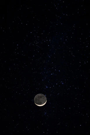 A mystical postcard showing a crescent moon surrounded by stars against a deep blue background.