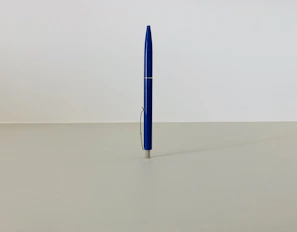 Close-up of a blue branded pen with a company logo on a white background.