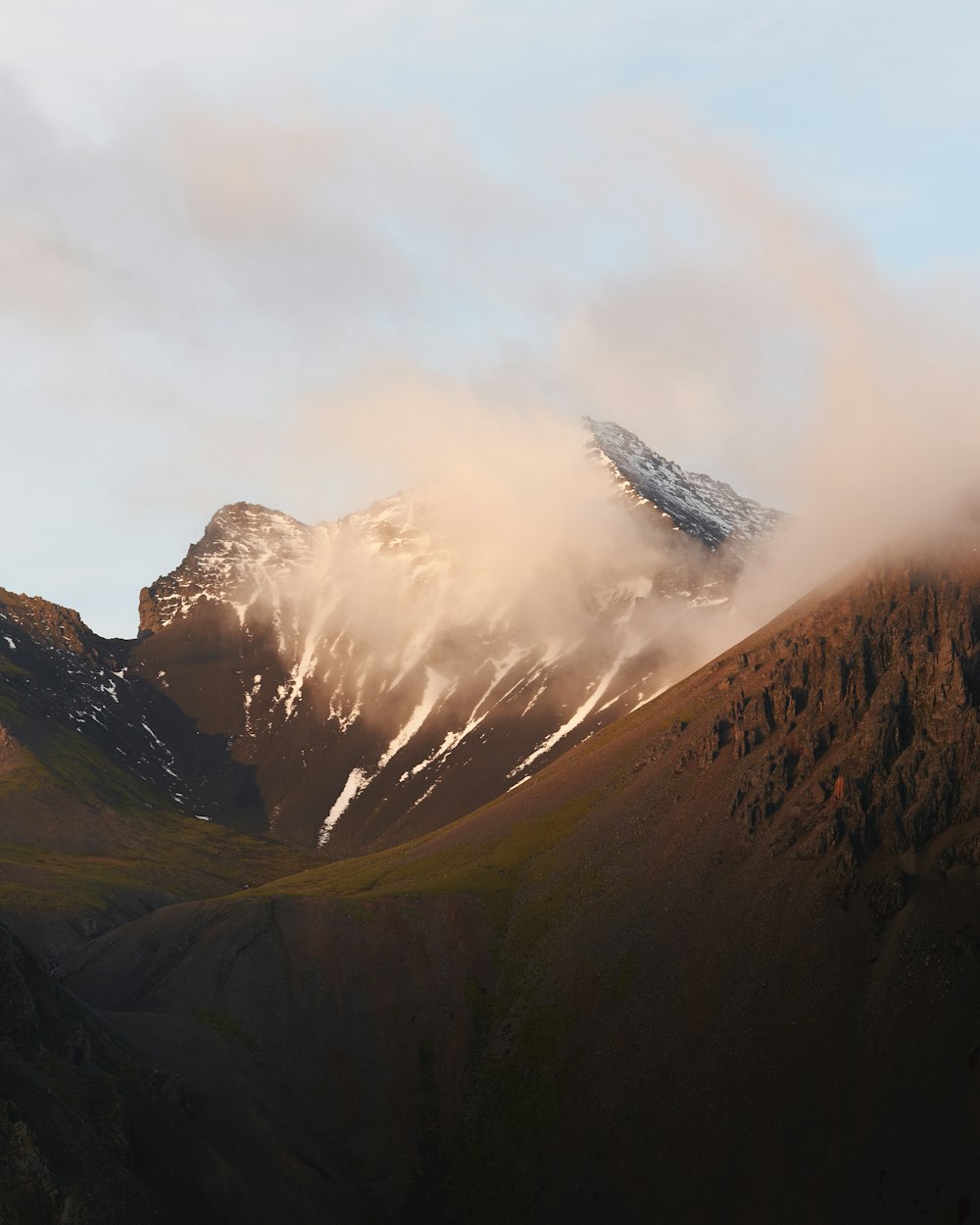 brown and black mountains under white clouds during daytime