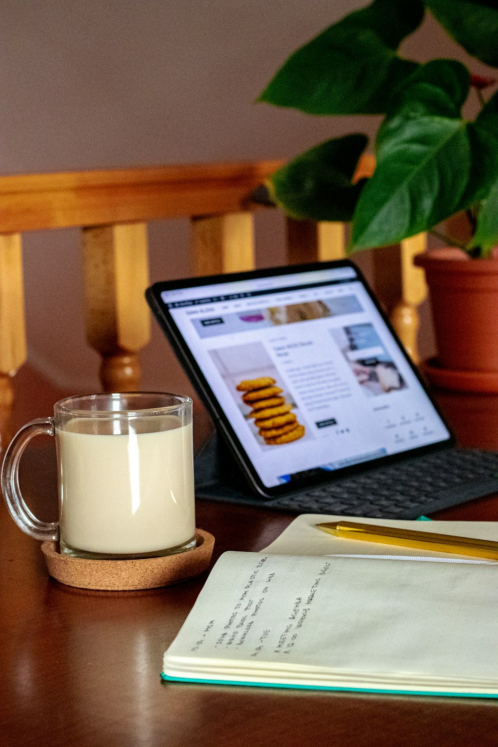 Weiße Keramiktasse neben MacBook Pro auf braunem Holztisch