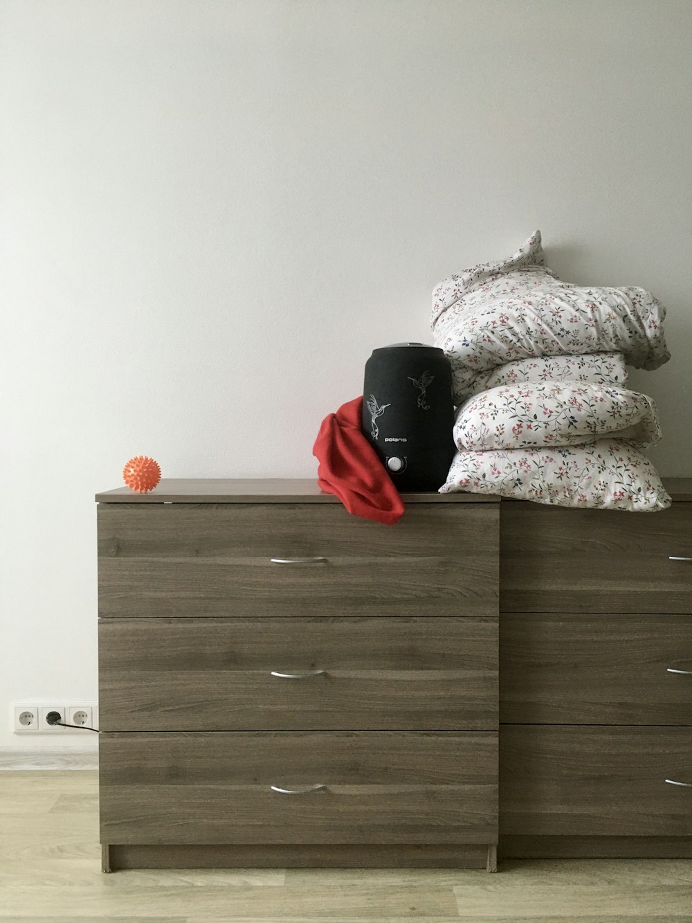 black and red backpack on brown wooden bed