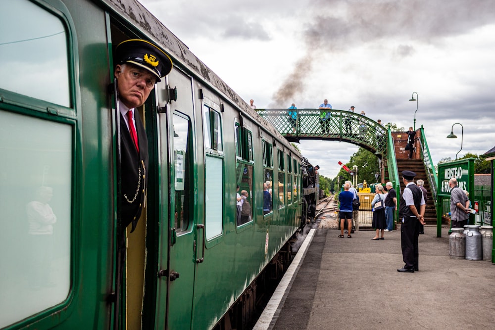a man in a uniform is looking out the window of a train