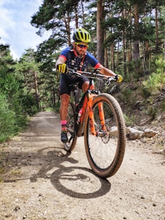 man in black and yellow bicycle suit riding on red and black mountain bike