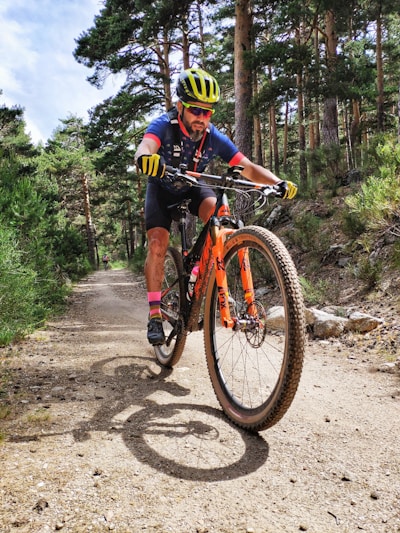 man in black and yellow bicycle suit riding on red and black mountain bike