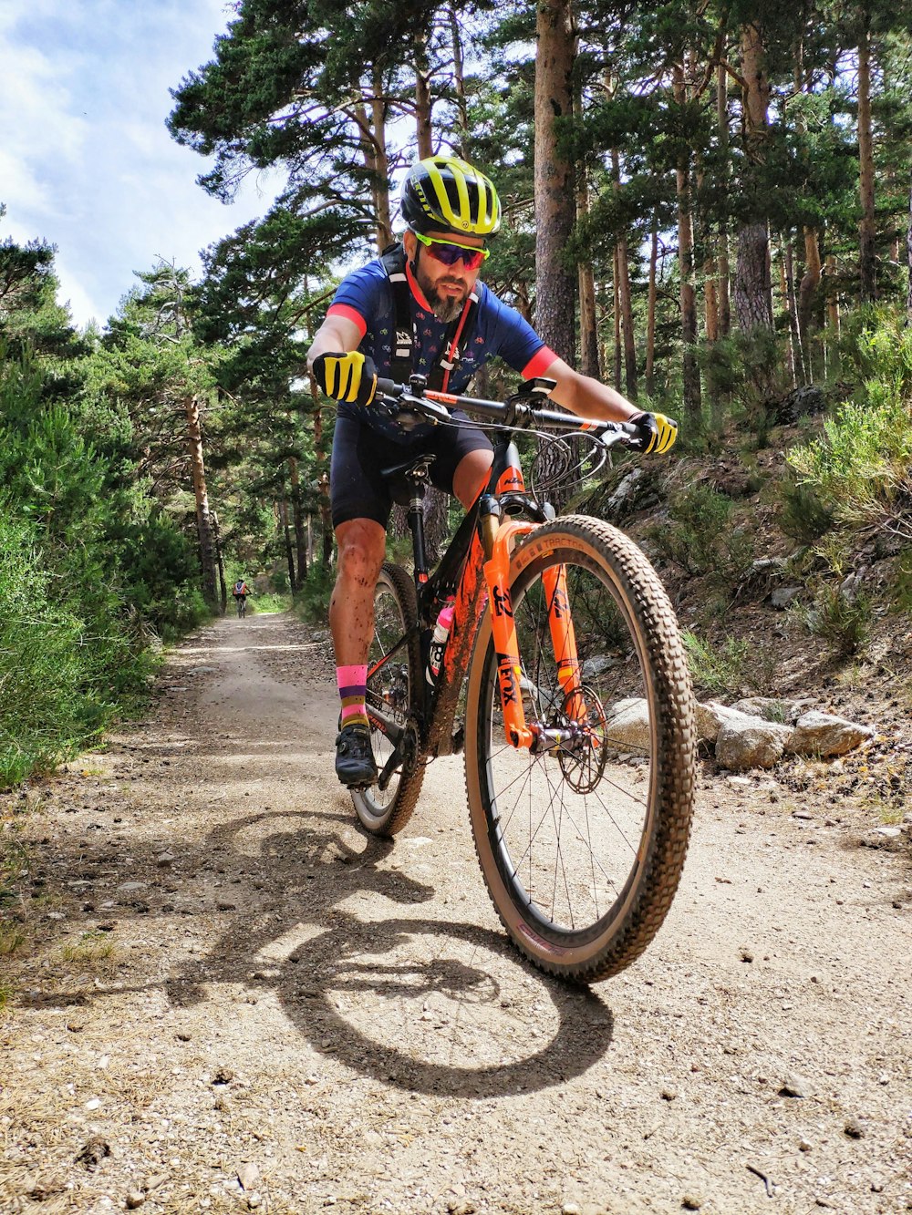 Mann im schwarz-gelben Fahrradanzug fährt auf rotem und schwarzem Mountainbike