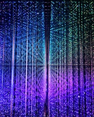 An array of vertical strings of lights creates a captivating, immersive display. The lights transition smoothly from purple at the bottom to blue and green at the top, forming a mesmerizing gradient effect. The arrangement gives a sense of depth and movement, as if exploring a futuristic, kaleidoscopic space.