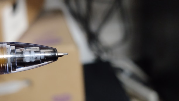 A close-up of a worker assembling high-quality pens on a factory line.
