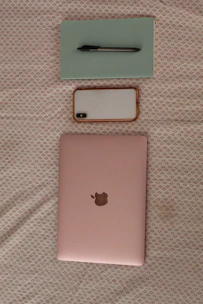 A sleek, elegant laptop backpack in soft pastel pink, displayed on a minimalist wooden table with a laptop and coffee cup nearby.