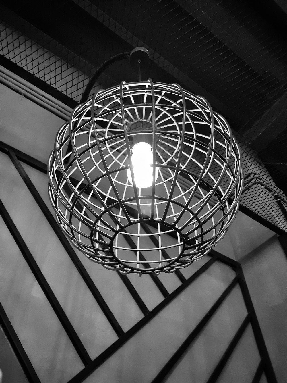 grayscale photo of round pendant lamp