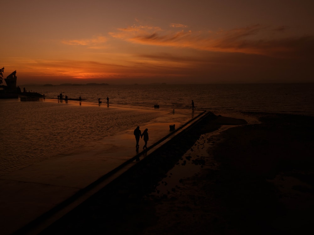 silhouette of people on beach during sunset