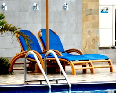 blue and white lounge chairs near swimming pool