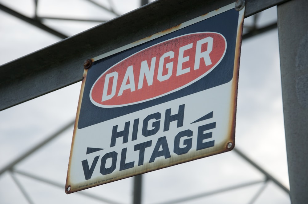 a danger sign hanging from the side of a metal pole