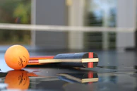 The compact netzkraft tool folded neatly next to a table tennis paddle and ball.
