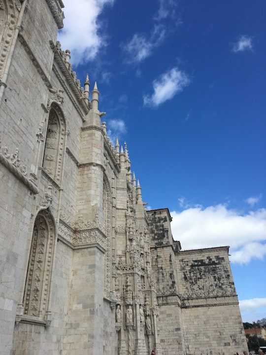brown concrete building under blue sky during daytime in Jerónimos Monastery Portugal