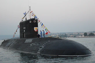 black ship on sea under gray sky during daytime