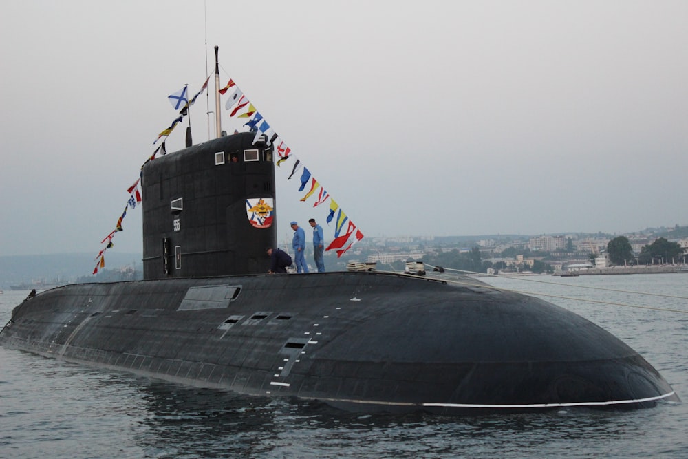 nave nera sul mare sotto il cielo grigio durante il giorno